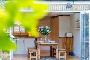 a kitchen with a table with a vase of flowers on it at STYLISH 3 BED COTTAGE, WALK 2 ALL SIGHTS & HIGH ST in Windsor
