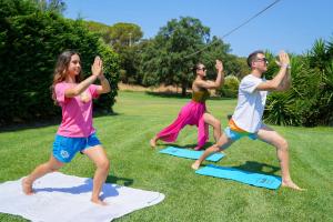 a group of people doing yoga on the grass at Hotel Le Acacie in Capoliveri