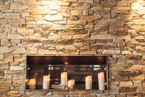 a fireplace with candles in a stone wall at Hotel Spescha in Lenzerheide