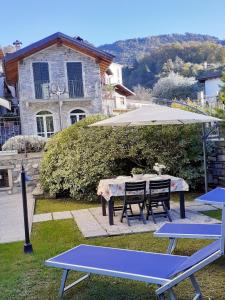 een picknicktafel met een parasol en 2 stoelen bij BELLAGIO DREAMS APT, pool, with private garden, near lake in Bellagio
