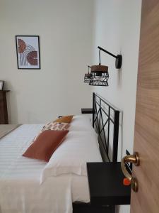 ein Schlafzimmer mit einem Bett mit einem Tisch und einer Lampe in der Unterkunft L'OLIVA CONTESA - alloggio turistico - la ROSSA in Gaeta