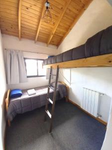 a room with two bunk beds and a ladder at Posada San Antonio in El Chalten