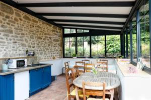 una cocina con armarios azules y una mesa con sillas en Des Feuilles et Des Hiboux, en Plescop