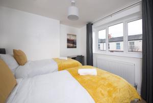 2 camas en una habitación con ventana en Air Host and Stay - Thomson House - Sleeps 4 2 mins walk from Stockport train station and town centre en Stockport