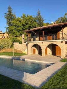 a house with a swimming pool in front of a building at Villa Maria in San Feliciano