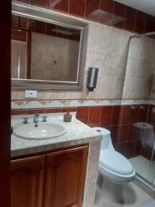 a bathroom with a sink and a toilet and a mirror at CIELITO LINDO in Santa Rosa de Cabal