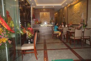 un restaurante con dos personas sentadas en una mesa en Hong Thien Ruby Hotel en Hue