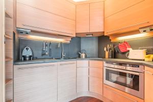 a kitchen with wooden cabinets and stainless steel appliances at Terrazza su Sestriere Lux in Sestriere