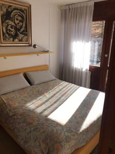 una camera con un letto e una finestra con un quadro di Appartamento Cervinia Cielo Alto direttamente sulle piste a Breuil-Cervinia