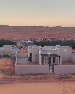 a white house in the middle of the desert at Private Sand Bond in Al Raka