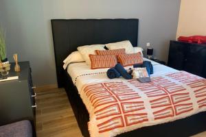 ein Schlafzimmer mit einem großen Bett mit roten und orangefarbenen Kissen in der Unterkunft Gite Studio indépendant au cœur du Luberon in Maubec
