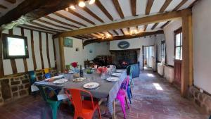 uma sala de jantar com uma mesa e cadeiras coloridas em La Lanterne: Grande maison à deux pas de la mer em La Chapelle-sur-Dun