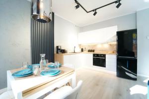 a kitchen with a table with blue plates on it at Apartamenty EverySky - Mickiewicza 30 in Jelenia Góra