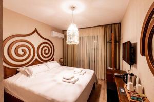 - une chambre avec un grand lit blanc et un lustre dans l'établissement My House Urla, à Izmir