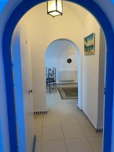 um corredor com um arco com uma mesa num quarto em BUNGALOW El HOUDA em Hammamet