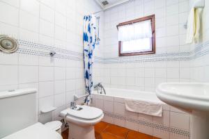 a bathroom with a toilet and a sink and a tub at Casa do Pinheiro with shared swimming pool in São Vicente Ferreira +38 photos