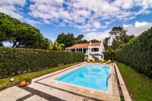 een zwembad in de tuin van een huis bij Casa do Pinheiro with shared swimming pool in São Vicente Ferreira
