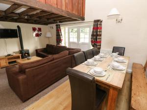 a living room with a table and a couch at Rafters Cottage in Walton East