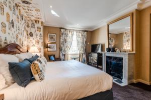 a bedroom with a large bed and a fireplace at Domaine les Crayères in Reims +42 photos