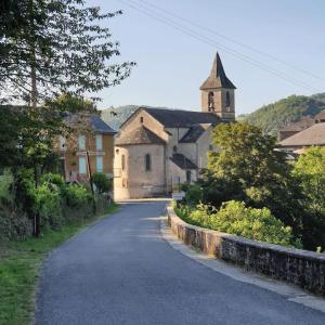 a road leading to a building with a church at Gîte du Presbytère in Ayssènes-la-Bacaresse