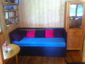 a blue couch with pink pillows in a room at Le chalet de Cavailla in Marmont-Pachas