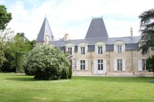 Bouaye的住宿－Château du Bois de La Noe，草坪上一座有两座塔楼的老房子