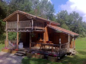 a log cabin with a porch and a deck at Le chalet de Cavailla in Marmont-Pachas