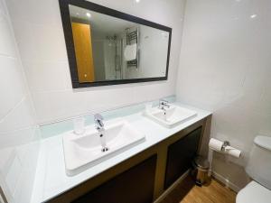 a bathroom with a sink, mirror, and toilet at The Star and Garter Hotel in Andover