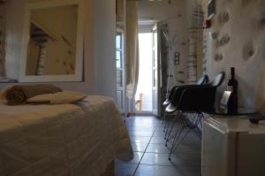 ein Schlafzimmer mit einem Bett, einem Tisch und einem Stuhl in der Unterkunft Villa Byzantino in Lefkes