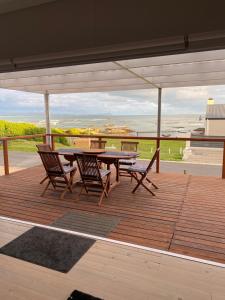 a patio with a table and chairs on a deck at Kleinbaai in Kleinbaai
