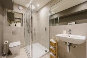 a bathroom with a shower toilet and a sink at Museum Apartments in Edinburgh