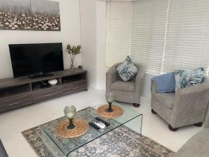 希尔克雷斯特Hillcrest Haven cottage 1的客厅配有2把椅子和平面电视