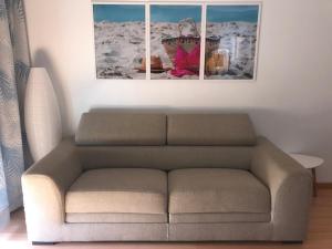 a couch in a living room with a picture on the wall at Beach House Carmen 2 in Monte Gordo