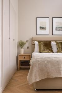 a bedroom with a white bed and white walls at Museum Apartments in Edinburgh