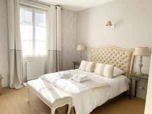 a white bedroom with a white bed and a window at Auberge du Chasseur in Grosrouvre