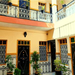 un bâtiment avec une porte et des plantes devant lui dans l'établissement Hotel Zagora, à Marrakech