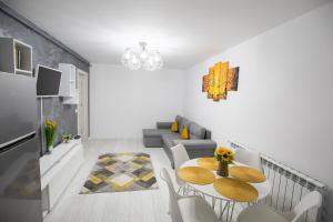 a white living room with a table and a couch at Apartament CENTRAL in Târgu Ocna
