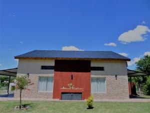 una casa con techo negro y puerta roja en Encanto Puntano en Potrero de los Funes