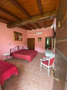 una camera da letto con pareti rosa, un letto e un tavolo di Agriturismo Montefosco a Sutri