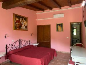 una camera da letto con pareti rosa e un letto con copriletto rosso di Agriturismo Montefosco a Sutri