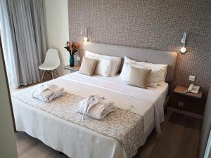 um quarto de hotel com uma cama com toalhas em Venus Beach Hotel em Pafos