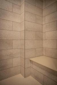 a white tiled bathroom with a tub in it at Hotel Broad Ripple in Indianapolis