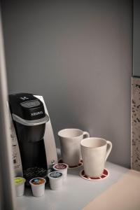 a coffee maker and two cups on a counter at Hotel Broad Ripple in Indianapolis