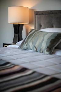 a bedroom with a bed with a lamp on a table at Hotel Broad Ripple in Indianapolis