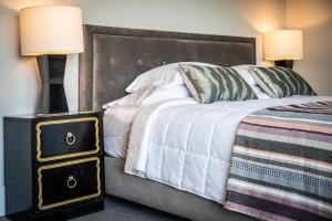 um quarto com uma cama e uma mesa de cabeceira com 2 candeeiros em Hotel Broad Ripple em Indianápolis