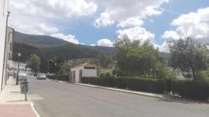 una calle vacía en un pueblo con una montaña en Casa Las Truchas en El Bosque