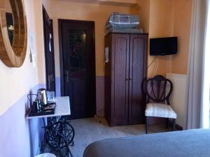 卡蘭巴卡的住宿－神話賓館，一间卧室配有木制橱柜和椅子