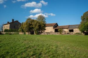 an old stone house with a large grass field at Edouard & Louise - Chambres d'hôtes in Limoges