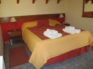 a hotel room with a bed with towels on it at Hosteria Maiten Escondido in Villa La Angostura