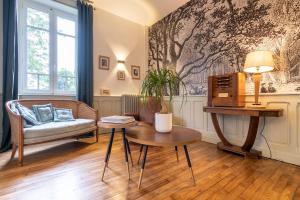 uma sala de estar com um sofá e uma mesa em Edouard & Louise - Chambres d'hôtes em Limoges